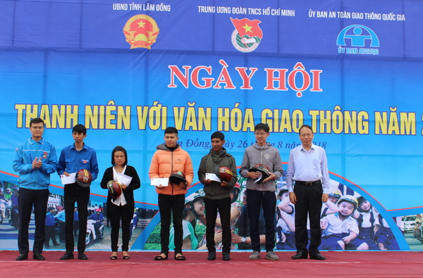 Đồng chí Bùi Quang Huy - Bí thư Trung ương Đoàn (ngoài cùng bên trái) và đồng chí Nguyễn Trọng Thái - Chánh văn phòng Ủy ban An toàn giao thông Quốc gia tặng quà và MBH đạt chuẩn cho các gia đình có nạn nhân bị tai nạn giao thông
